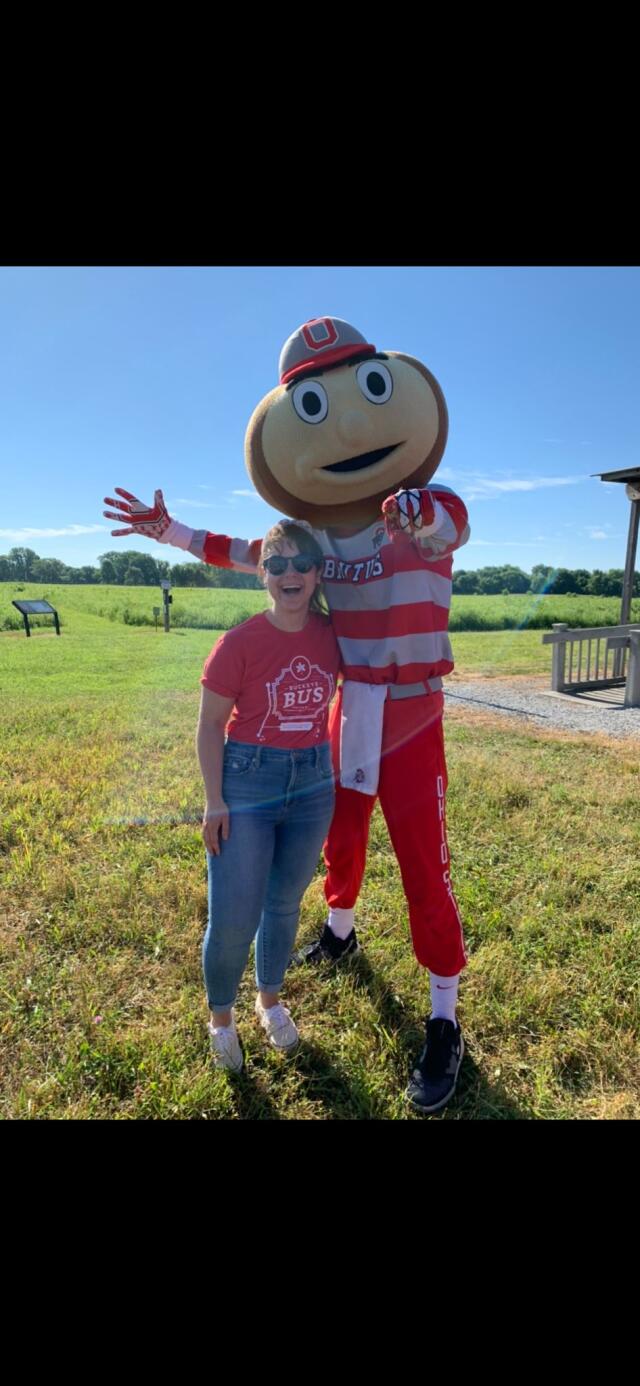Katie Conner the vice president of the council of graduate students stands with Brutus Buckeye